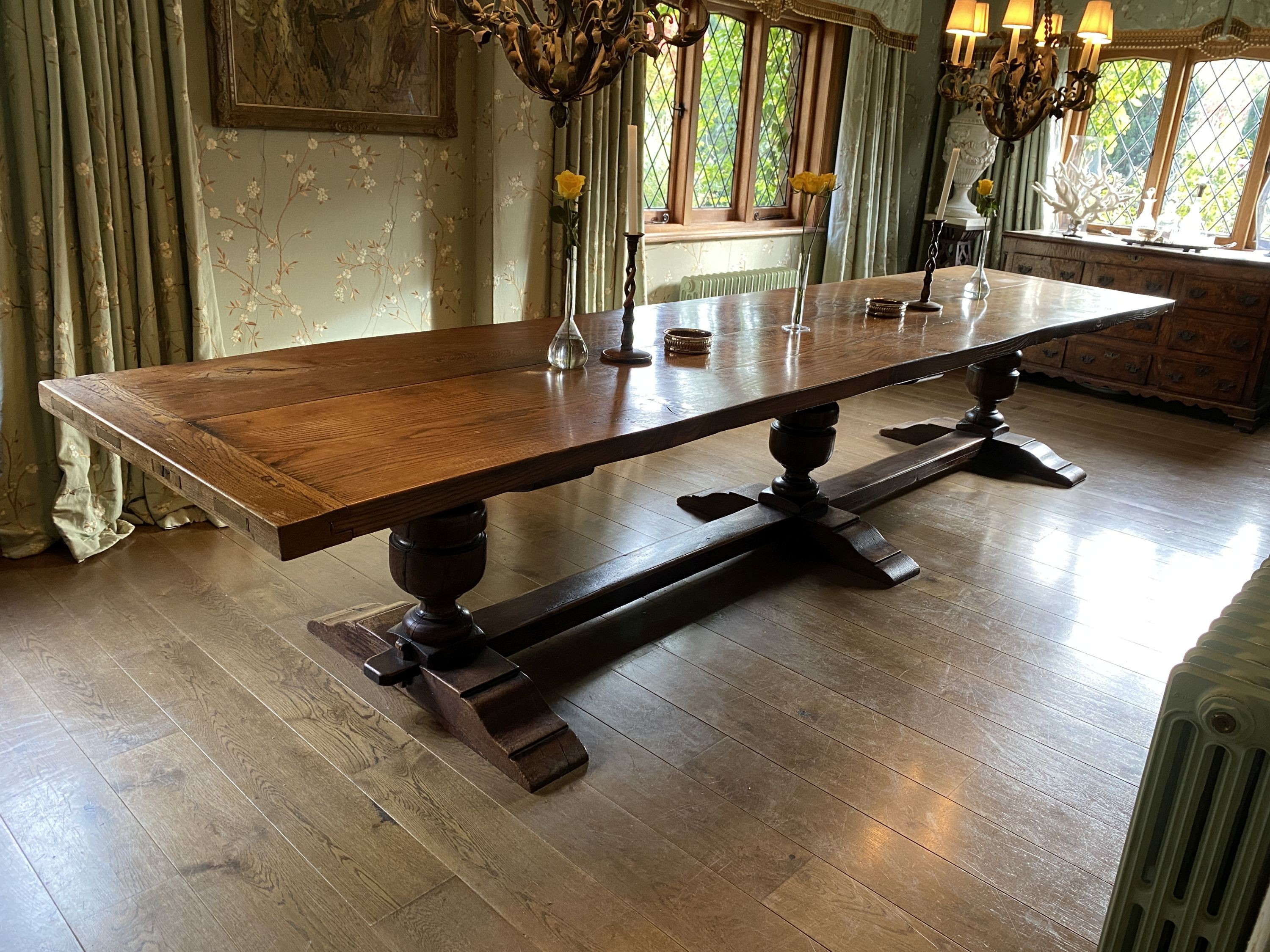 An impressively large 17th century style oak refectory table, with twin plank top on triple baluster supports and trestle foot, width 430cm depth 99cm height 74cm